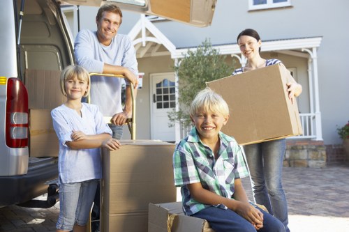 Professional movers carrying furniture from a Fulham flat with stair access